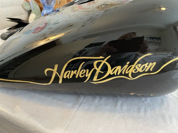Airbrush- Harley auf einen schwarzen Motorradtank wurde mit gold Harley Davidson geairbrusht