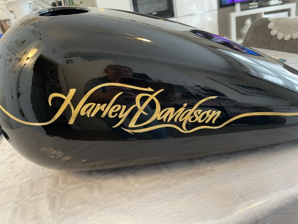Airbrush-Harley auf einen schwarzen Motorradtank wurde mit gold Harley Davidson geairbrusht
