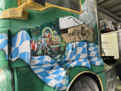Airbrush-Sattelschlepper es wurde ein Führerhaus grün geairbrusht in blau-weiss und brauntönen es wurde ein Zelt und ein Maßkrug sowie eine Breze auf die Seitentür geairbrush