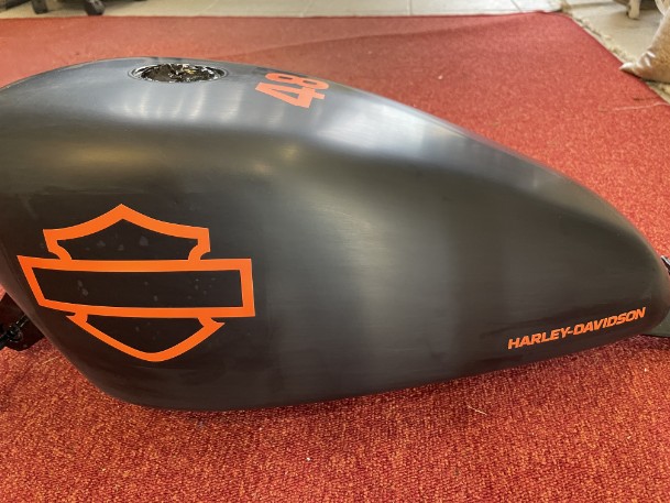 Airbrush-harley es wurde auf ein schwarzer Tank in orange ein Logo geairbrusht
